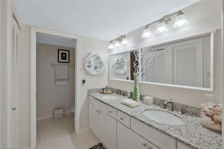 Full bath featuring double vanity and a closet