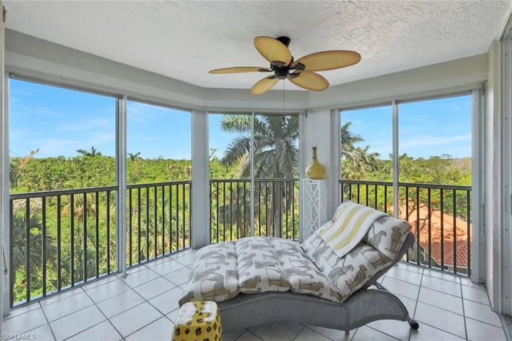 Sunroom / solarium with tile patterned flooring, a textured ceiling, and plenty of natural light