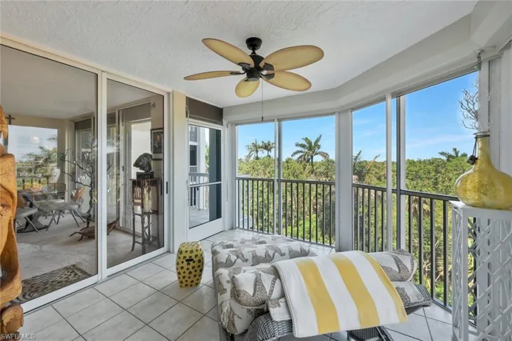 Sunroom / solarium featuring a ceiling fan and a balcony