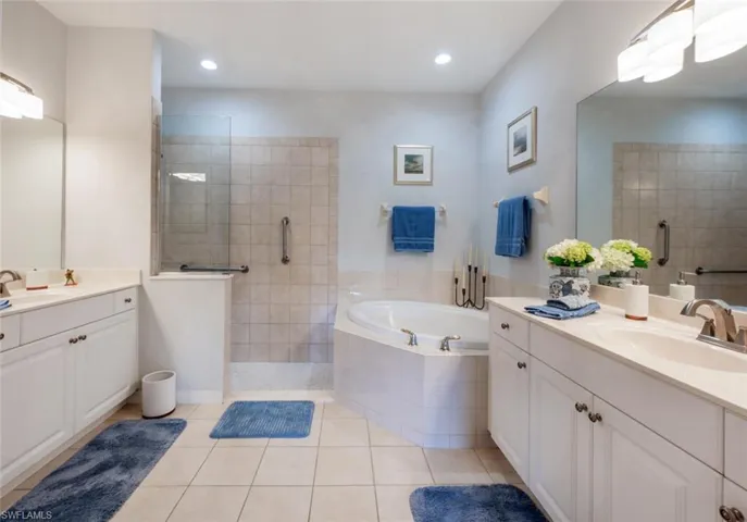 Full bath with a garden tub, walk in shower, a sink, and tile patterned floors