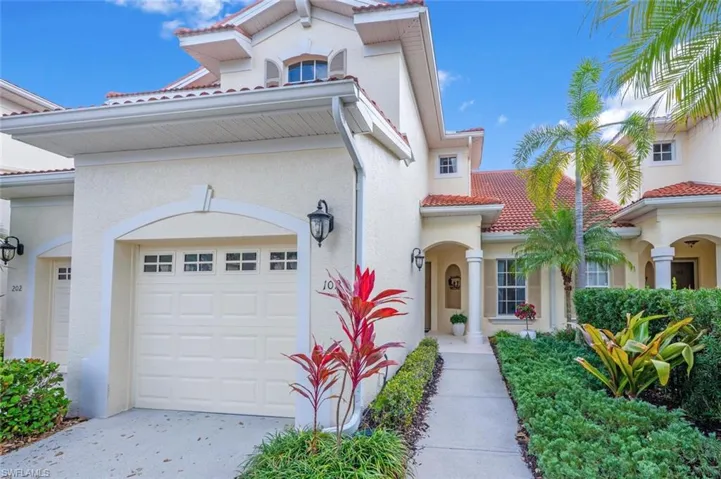 View of front of home featuring an attached garage, driveway, a tiled roof, and stucco siding