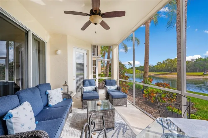 Sunroom with ceiling fan and a water view