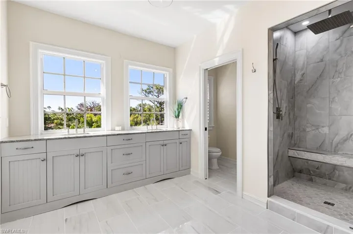 Walk in shower with floor to ceiling tile and a rain showerhead! Nice bench seating! Private water closet.