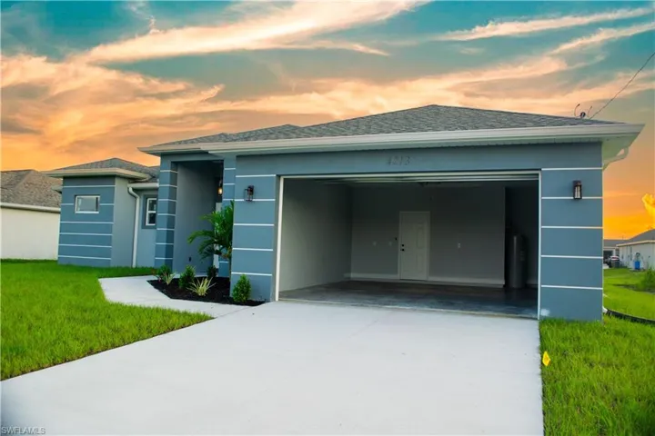 View of front of property with a lawn, water heater, and a garage