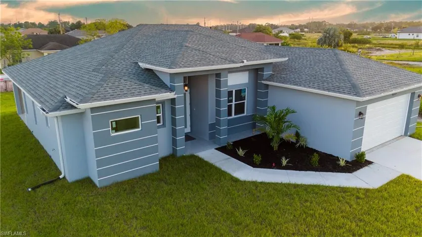 View of front facade with a yard and a garage
