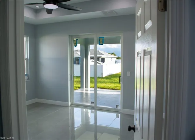 Entryway with light tile patterned flooring, ceiling fan, and plenty of natural light