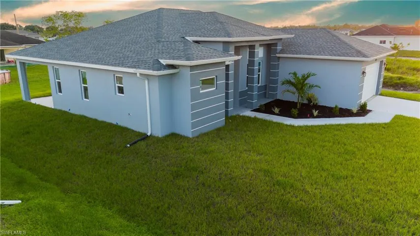 Property exterior at dusk featuring a lawn and a garage