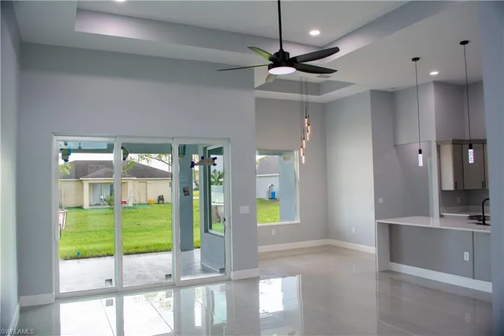 Entryway with a raised ceiling, sink, and ceiling fan