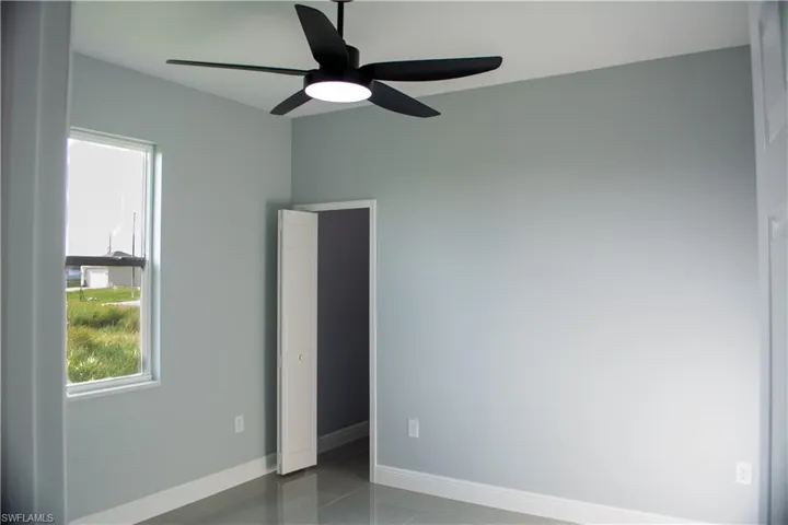 Tiled spare room with ceiling fan