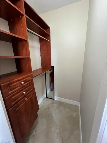 Spacious closet featuring light tile flooring