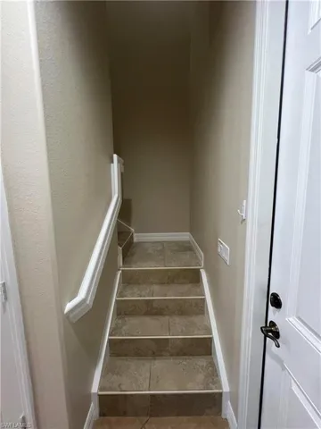 Stairway featuring dark tile floors