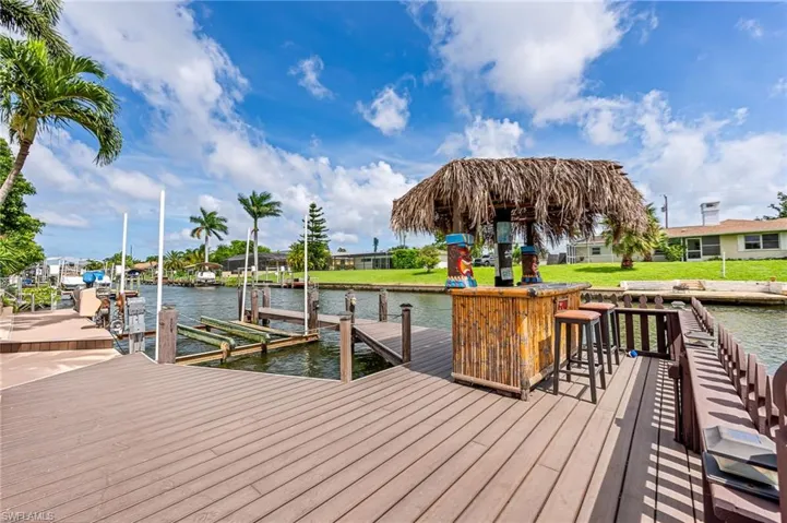 View of dock with a yard and a water view