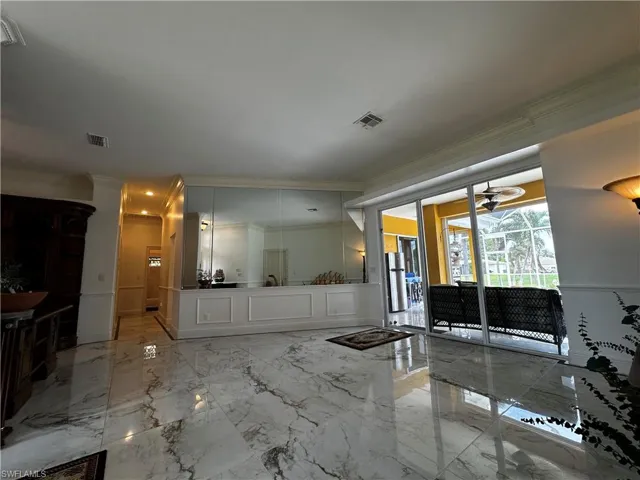 Bathroom with crown molding, marble tiled flooring, and vanity