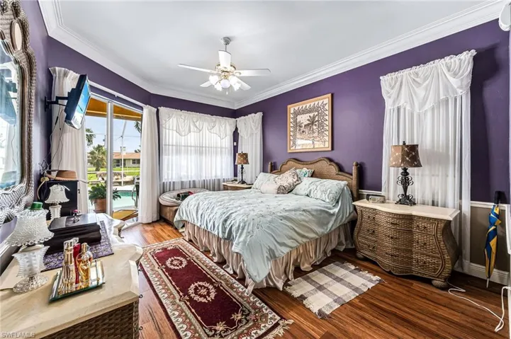 Bedroom with access to outside, ornamental molding, hardwood / wood-style floors, and ceiling fan