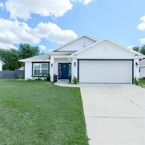 Single story home featuring stucco siding, a garage, and concrete driveway