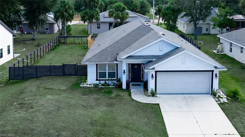 Ranch-style house with stucco siding, a garage, driveway, and roof with shingles