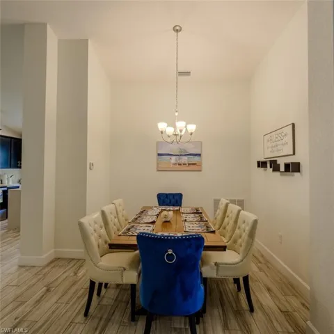 Dining space featuring wood finish floors, suspended lighting, and lofted ceiling