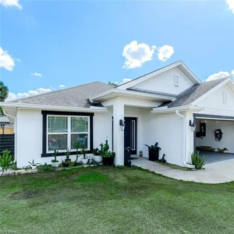 Ranch-style house featuring stucco siding, an attached garage, and a shingled roof