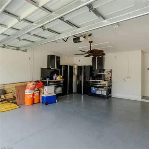 Garage featuring a ceiling fan and electric water heater