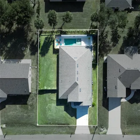 Aerial view of property and surrounding area featuring property boundaries highlighted and a pool area