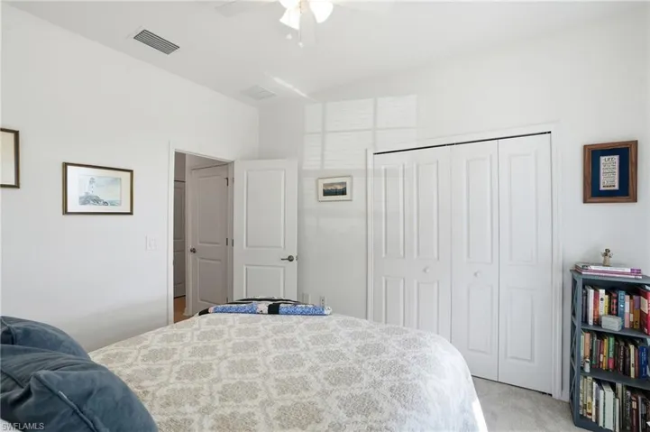 Bedroom featuring light colored carpet, a closet, and a ceiling fan