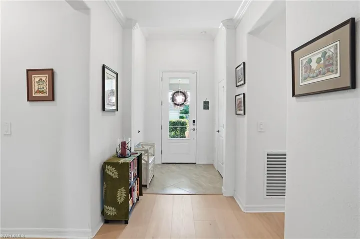 Entryway featuring crown molding and light wood-style flooring