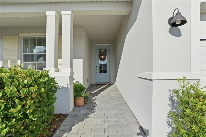 View of exterior entry featuring stucco siding and covered porch