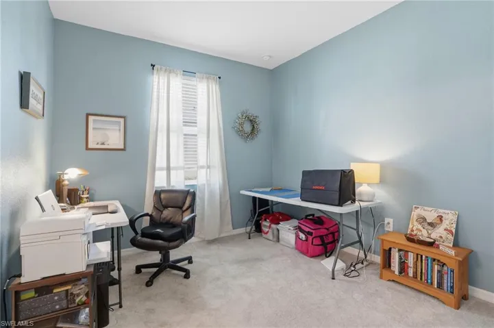 Home office with light colored carpet and baseboards