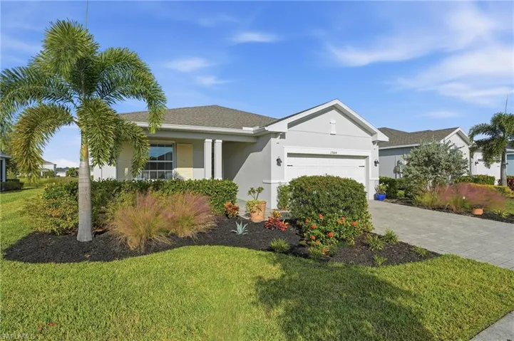 Ranch-style house with stucco siding, a front yard, decorative driveway, a garage, and covered porch