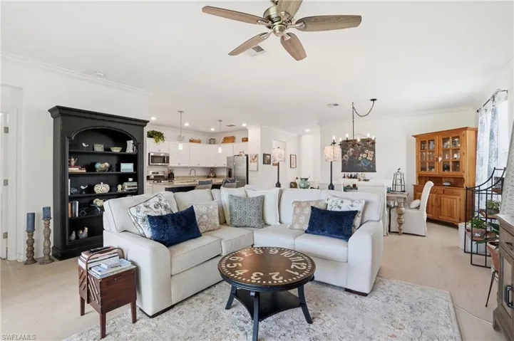 Living room featuring ornamental molding, light wood-style floors, and ceiling fan