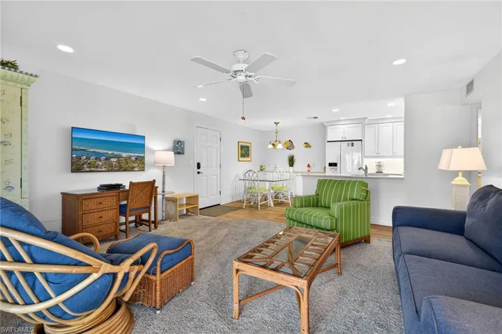 Living area featuring recessed lighting, ceiling fan, wood finished floors, and a chandelier