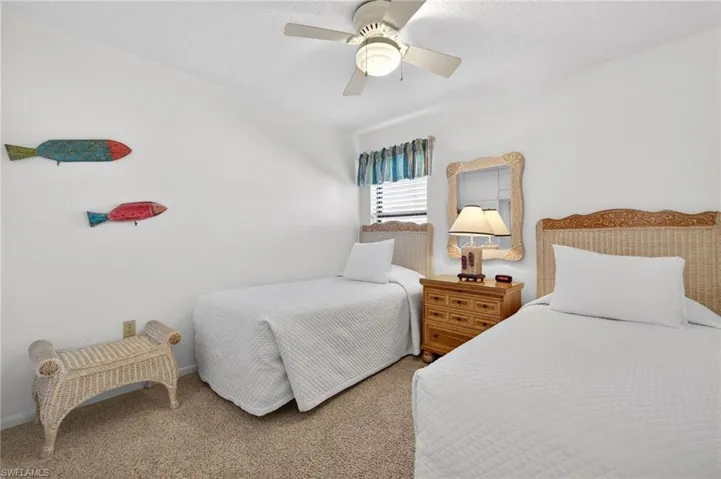 Carpeted bedroom with ceiling fan and a textured ceiling