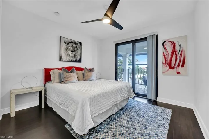 Bedroom featuring access to exterior, dark wood-style floors, and a ceiling fan