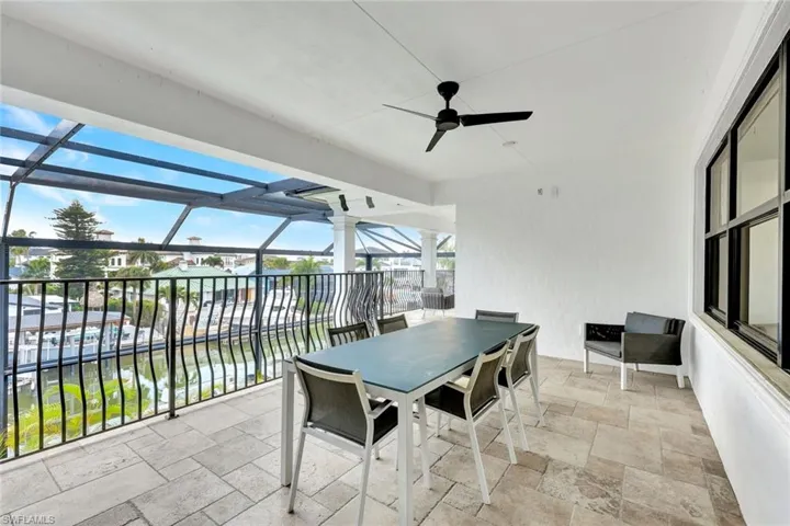 View of patio / terrace with ceiling fan, outdoor dining space, and glass enclosure