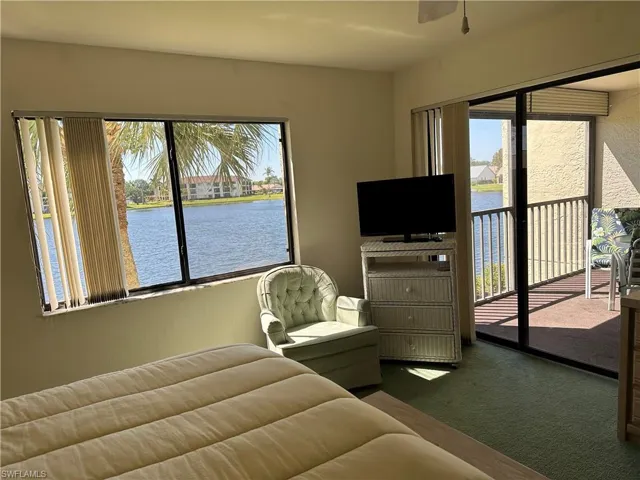 Bedroom featuring a water view, carpet, and multiple windows