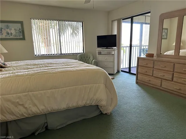 Carpeted bedroom featuring access to exterior and ceiling fan