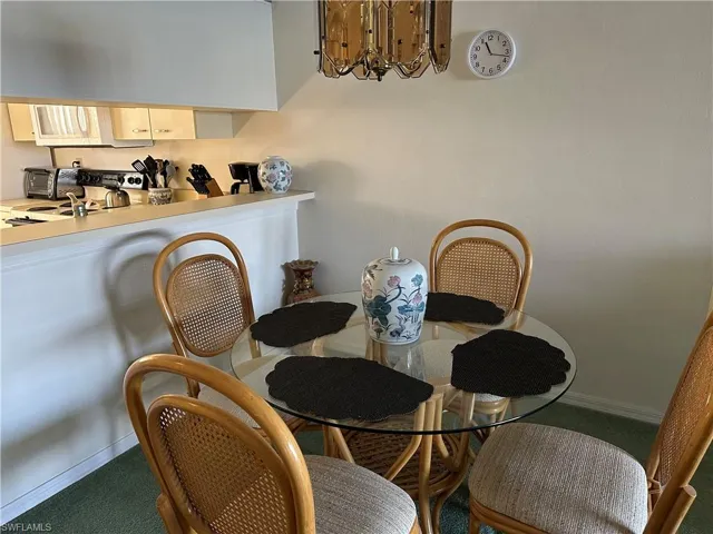 Dining space featuring a notable chandelier and carpet flooring