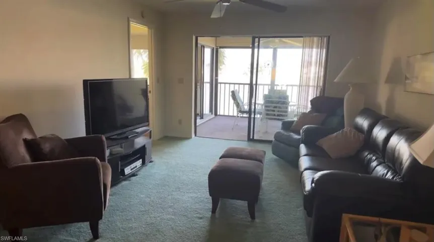 Living room featuring carpet flooring and ceiling fan