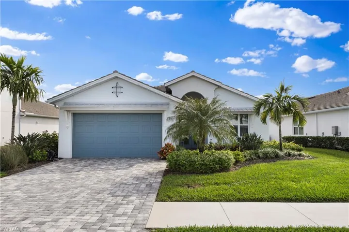 Single story home with a garage and a front lawn