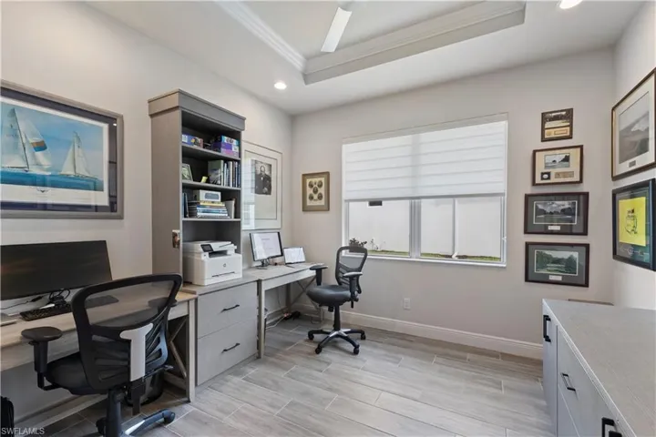 Office area with ornamental molding and a tray ceiling
