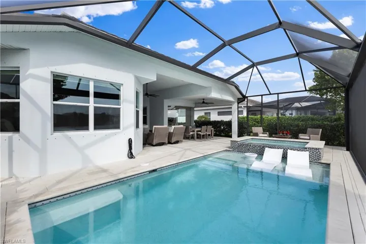 View of swimming pool with an outdoor living space, an in ground hot tub, a patio, ceiling fan, and screen enclosure