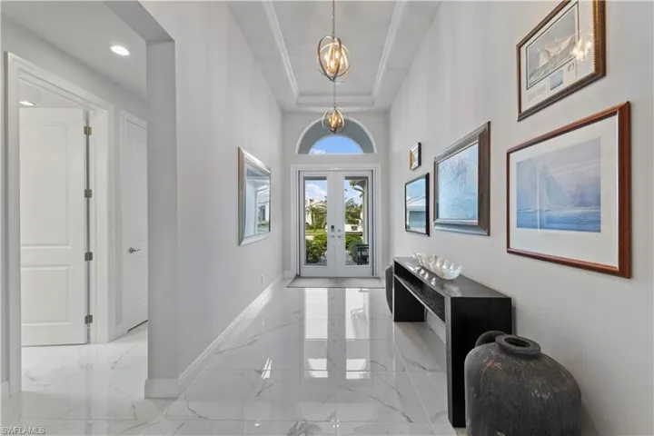 Tiled foyer entrance with french doors and a tray ceiling