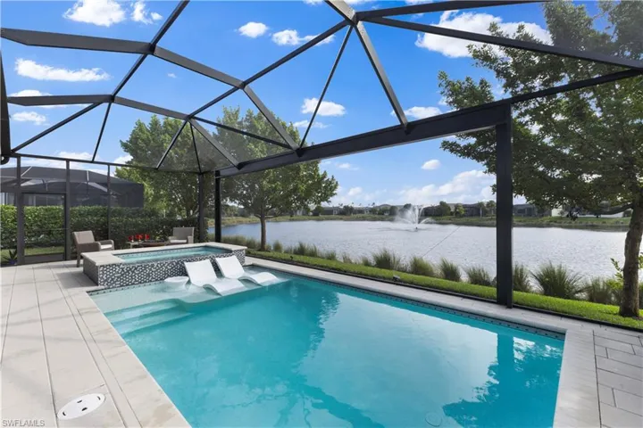 View of pool featuring an in ground hot tub, a lanai, and a water view