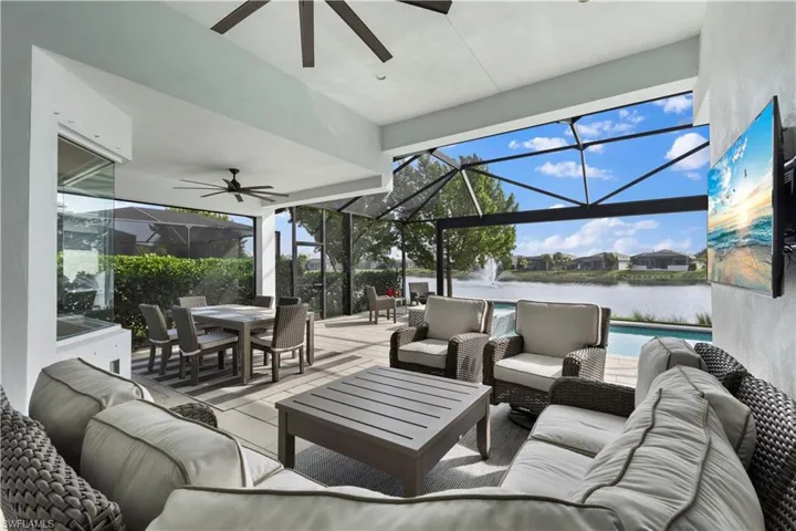 Large covered lanai with a water view and ceiling fan