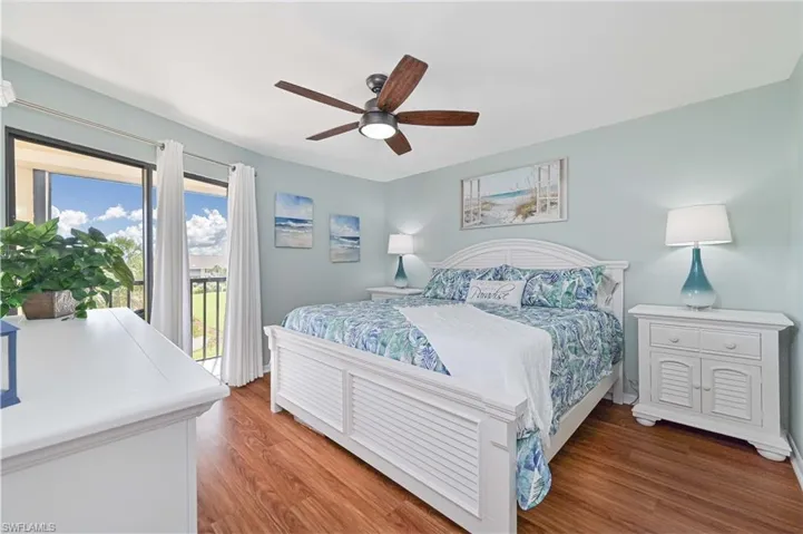 Bedroom with access to exterior, light wood finished floors, and a ceiling fan