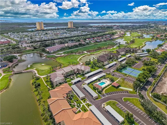 Aerial view of residential area with a golf course and a nearby body of water