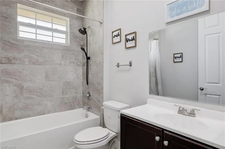 Full bathroom with shower / bath combination with curtain, toilet, and vanity