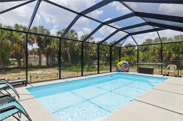 View of pool with a patio area and a lanai
