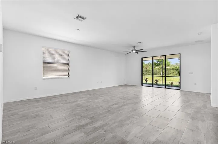 Great room featuring a ceiling fan, baseboards, and tile flooring
