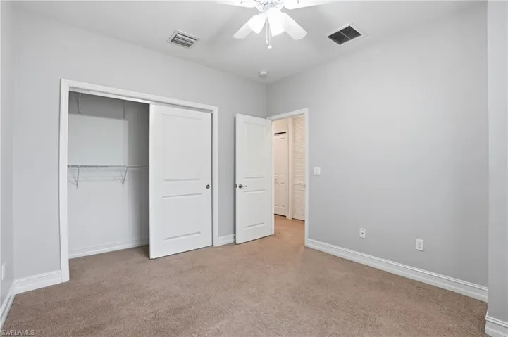 Unfurnished bedroom with a ceiling fan, a closet, and carpet flooring